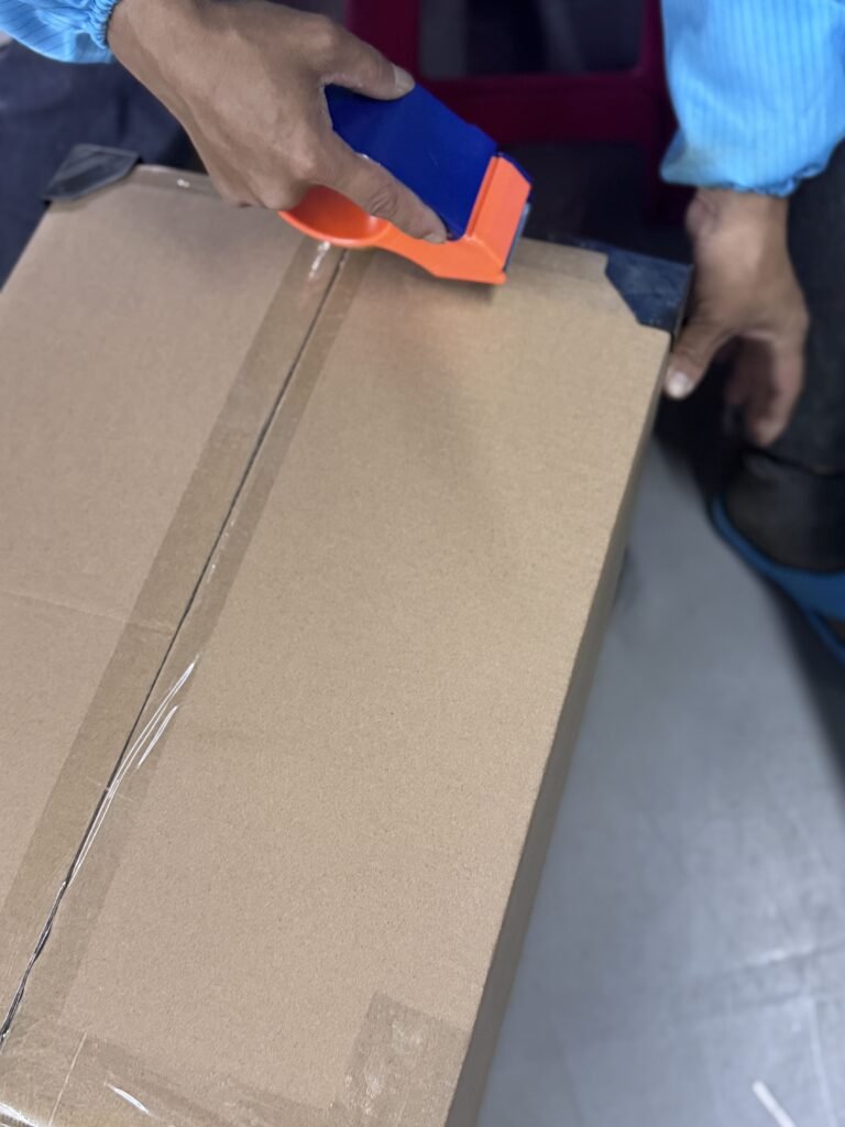 Warehouse staff sealing export cartons with protective corner guards to prevent damage during international shipping.