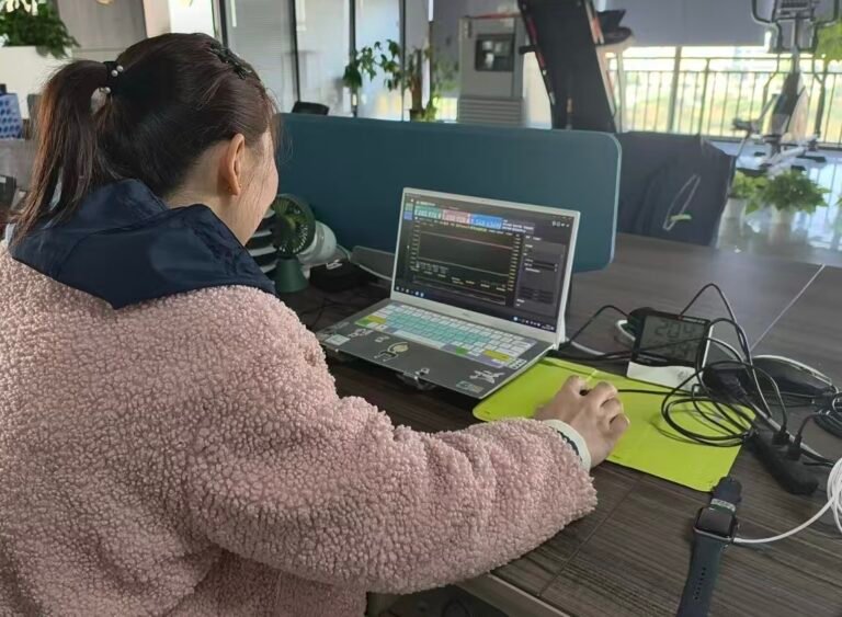 R&D engineer analyzing real-time performance data and charging stability curves for wireless charger prototypes.